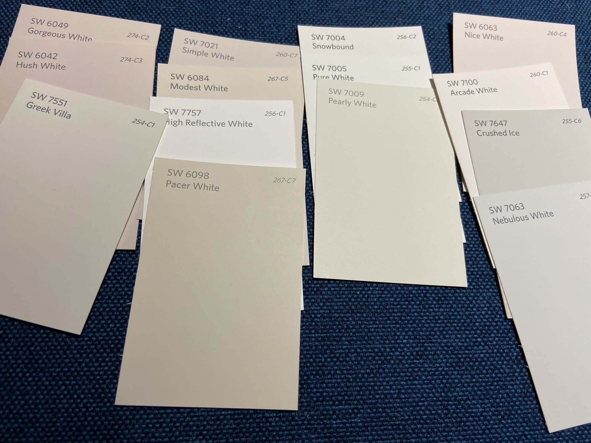 A photograph of rectangular white paint samples on a fabric background.