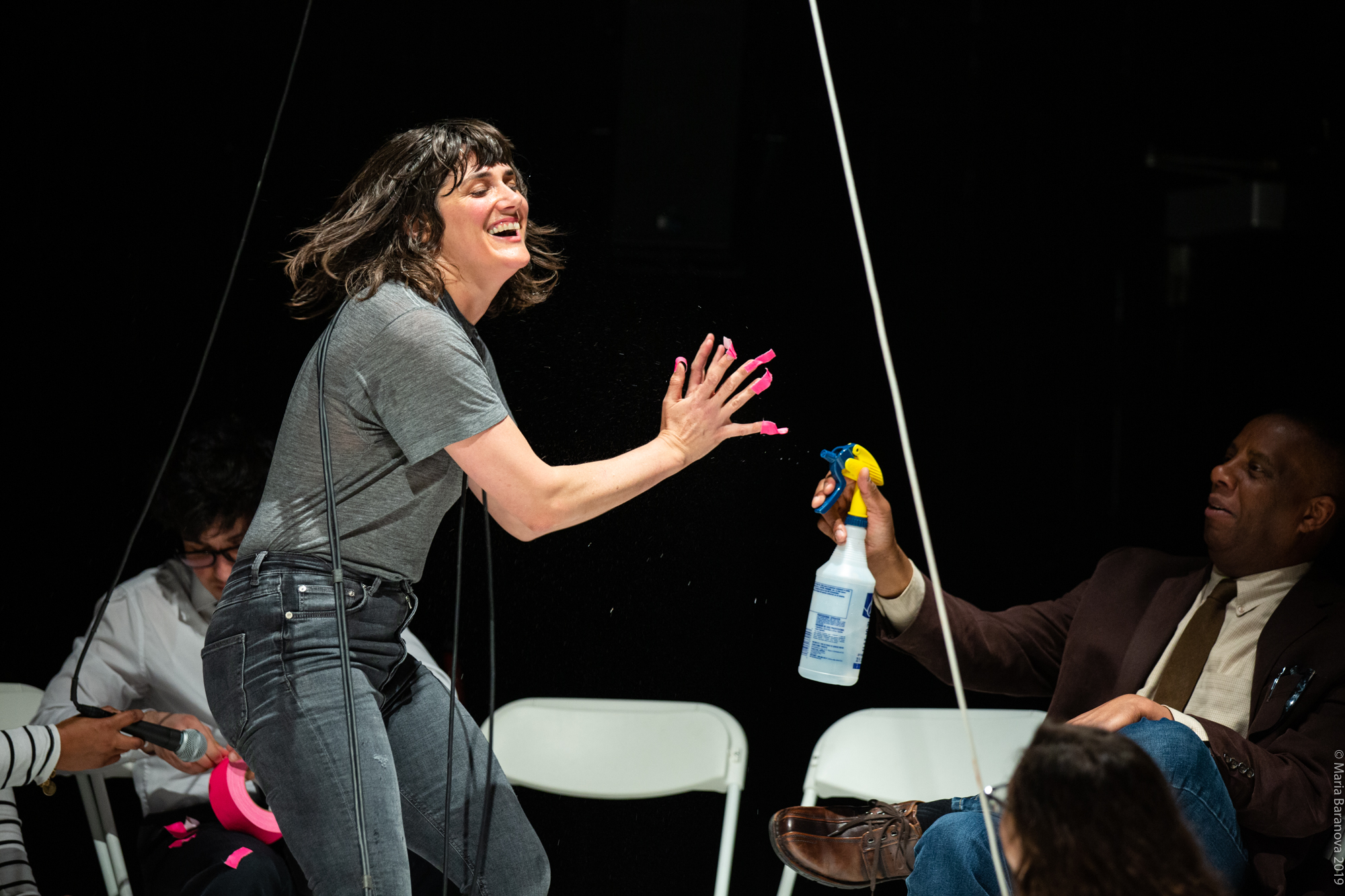 Faye Driscoll being sprayed with a bottle by and audience member.