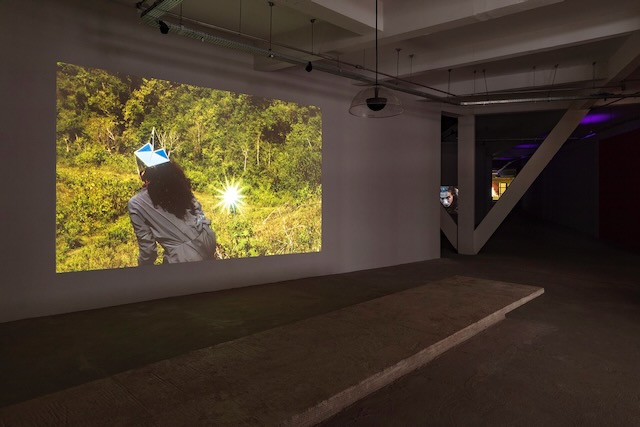 A museum installation showing a film on a screen.