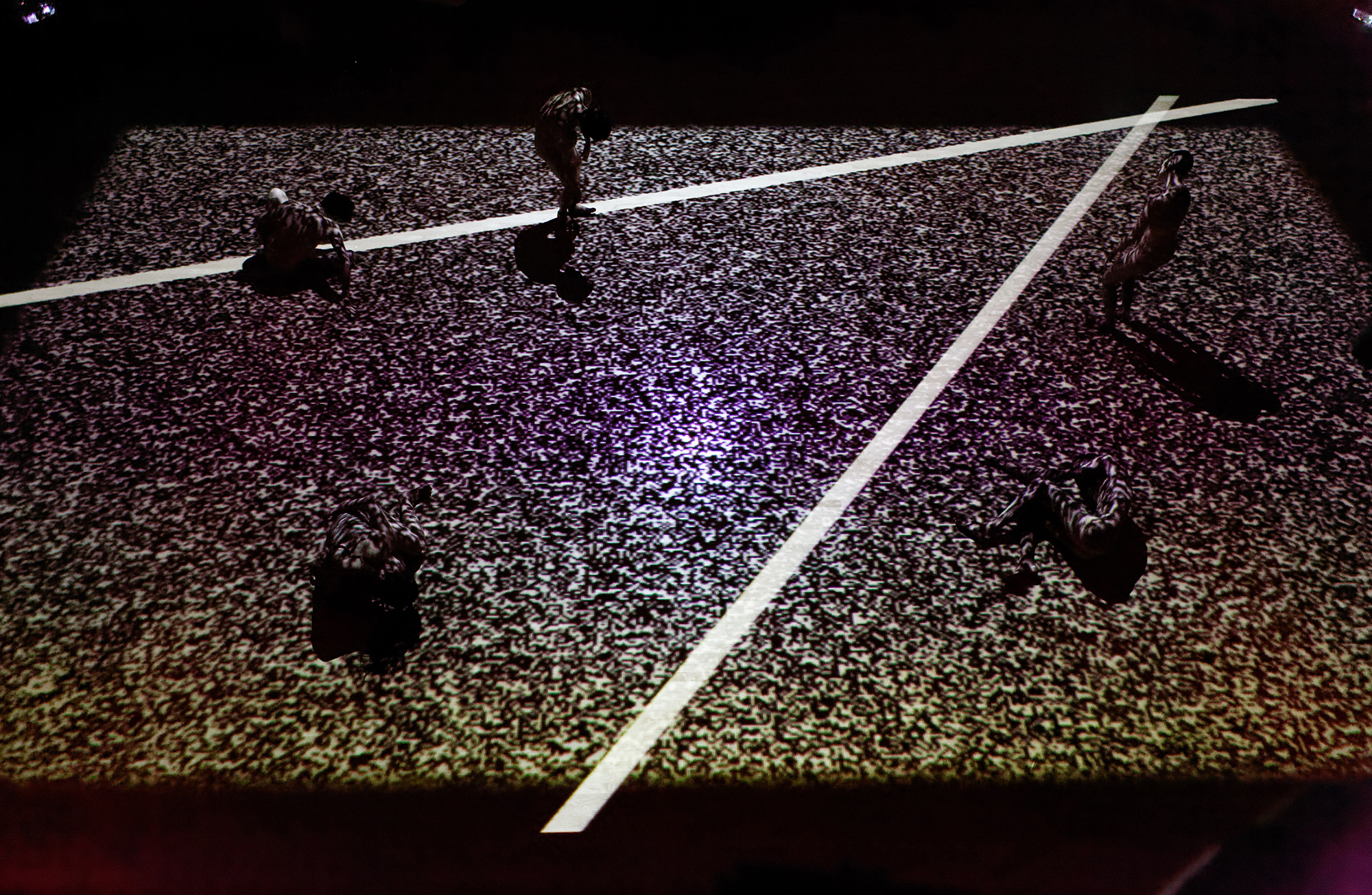 Five performers move slowly under the video projection of dots and lines.