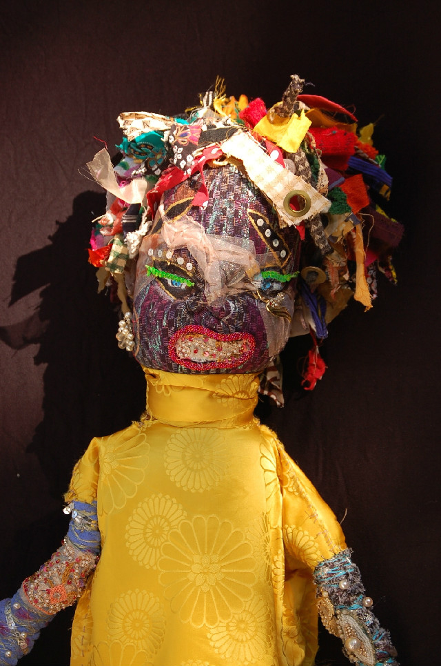 large fabric doll embellished with beads and paint