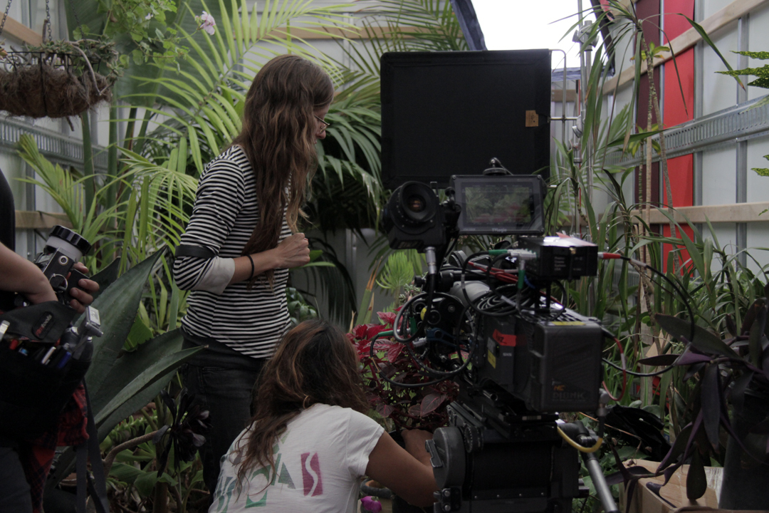 A woman directing behind a movie camera.