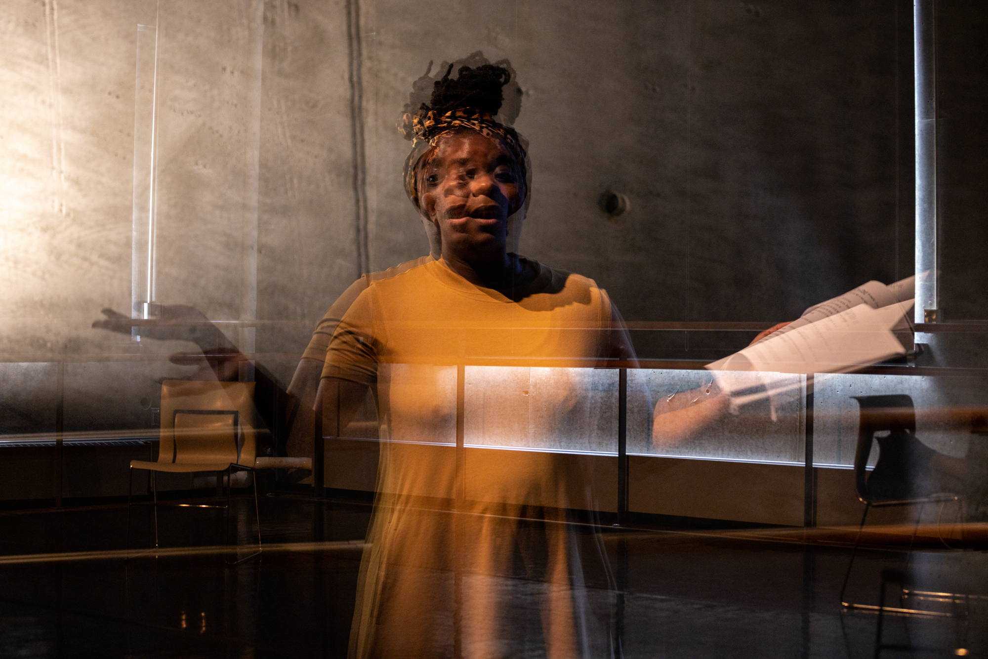 A Black woman in a double image, in an orange/brown dress, in a state of expressiveness.