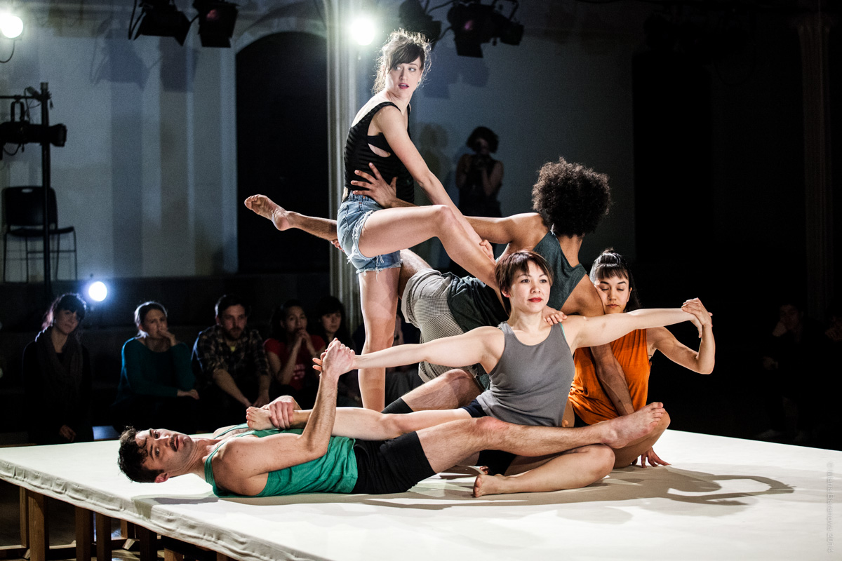 Several dancers onstage with entangled limbs.