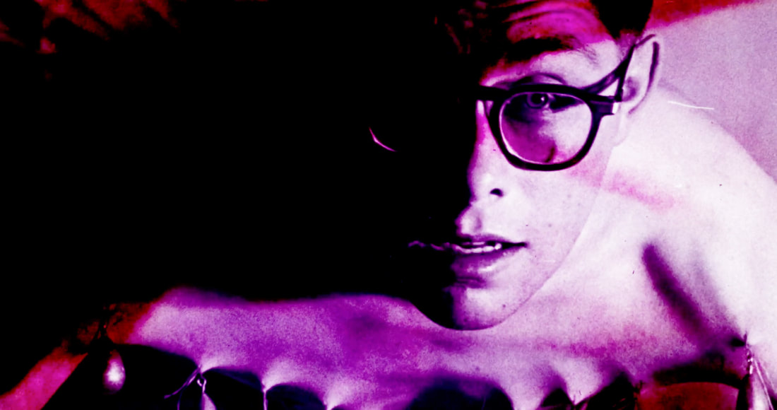 A pink cast Fakir Musafar gazes into the camera.