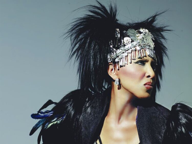 Image of Nona Hendryx, an African American woman, wearing a black feather jacket and silver headdress