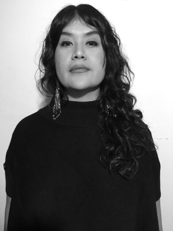 Black and grey image of artist Nani Chacon, artist faces camera face forward and looks straight into camera.