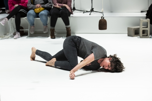 A person contorted on a white floor.
