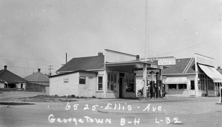 A black and white photograph of an abandoned gas station.