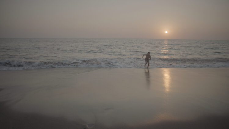 A child running in the ocean.
